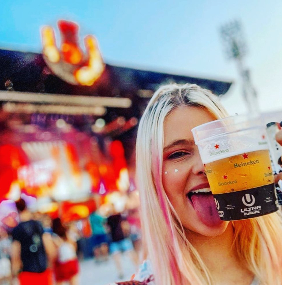 Printed festival cups held by attendees at an event