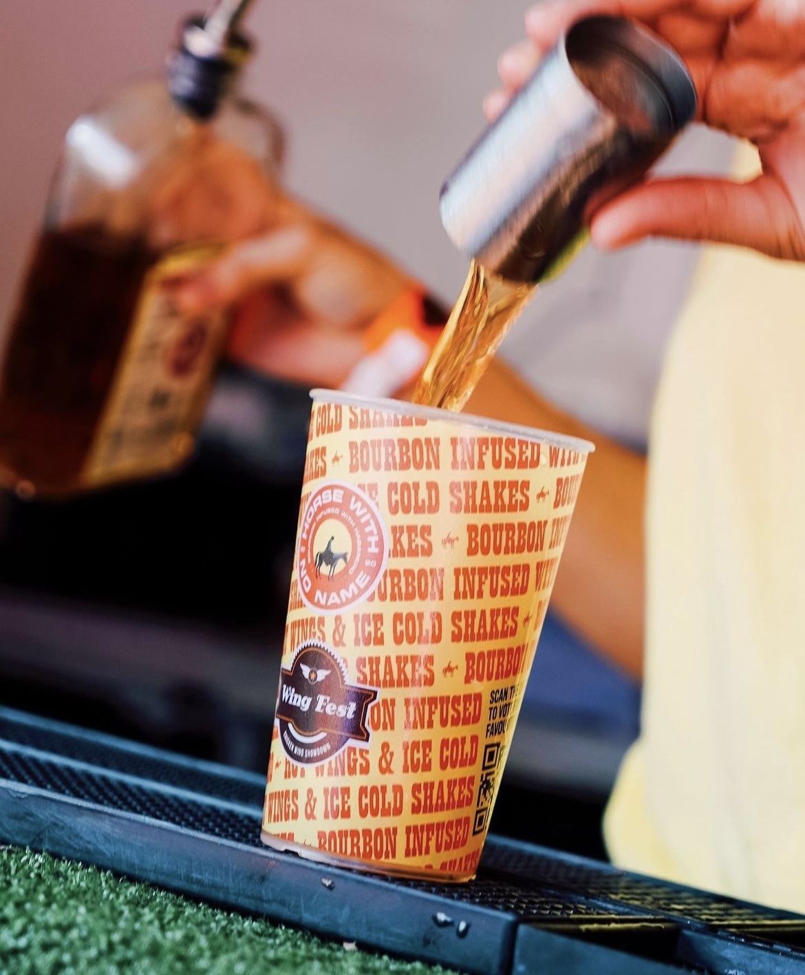 Festival pint cups lined up for beer service at a busy bar